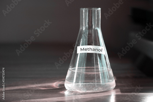 Methanol in a glass flask. Sunlight passes through the bulb and creates refraction. Methanol chemical reagent concept. photo