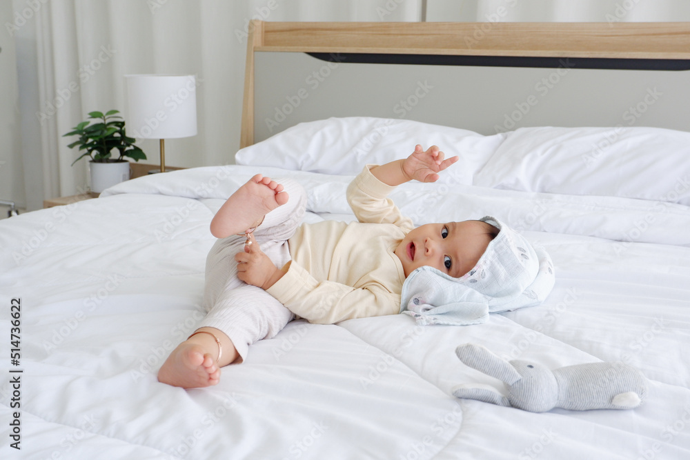A cute little boy is sitting on a white mattress with a happy smile. A cute little boy is sitting on a white mattress with a happy smile.