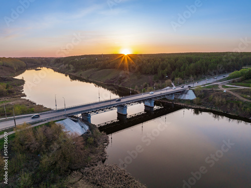 Beautiful view of the bridge across the Iset river in the city of Kamensk-Uralsky at sunset in spring. Kamensk-Uralskiy, Sverdlovsk region, Ural mountains, Russia. photo