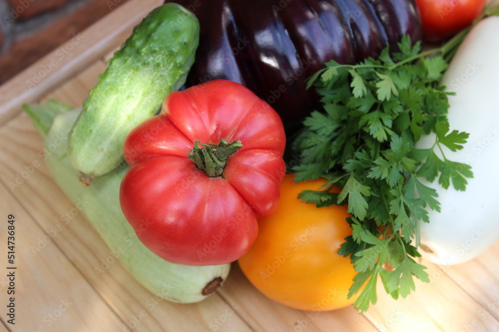 Tomato,, cucumber, zucchini on background of wooden boards. Organic vegetables.
