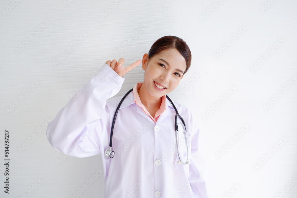 A smiling, beautiful Asian female doctor puts a stethoscope on her shoulder. wearing a white robe on a white background. A smiling, beautiful Asian female doctor puts a stethoscope on her shoulder. wearing a white robe on a white background.