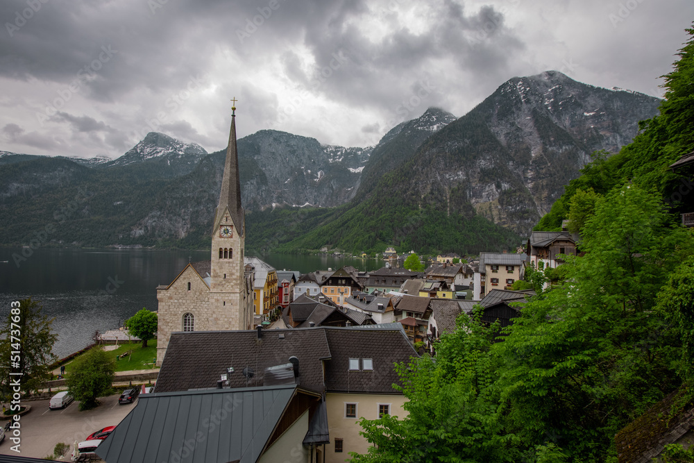 Beautiful church in Hallstatt, Austria, viewed from a street in the city, with some houses in the foreground. Typical austrian city, famous for its picturesque look.