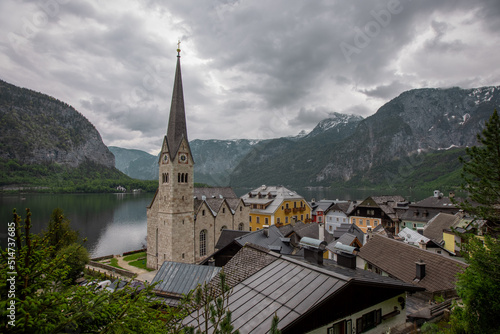 Beautiful church in Hallstatt  Austria  viewed from a street in the city  with some houses in the foreground. Typical austrian city  famous for its picturesque look.