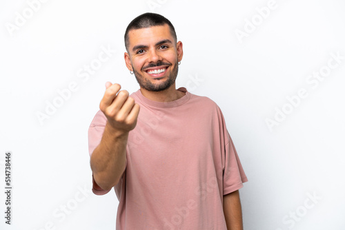 Young caucasian man isolated on white background making money gesture © luismolinero