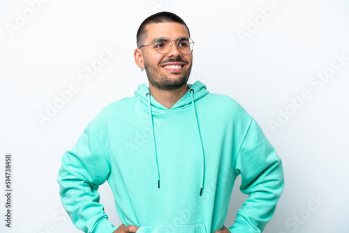 Young caucasian man isolated on white background posing with arms at hip and smiling © luismolinero