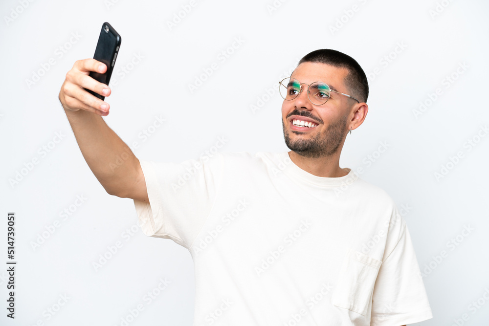 Young caucasian man isolated on white background making a selfie with mobile phone Young caucasian man isolated on white background making a selfie with mobile phone