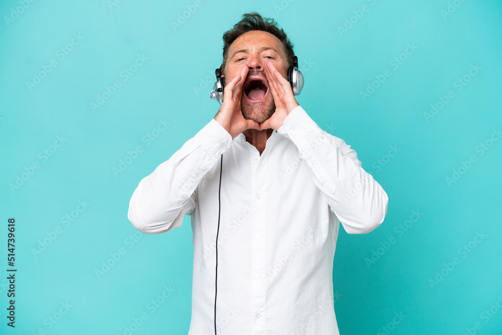 Telemarketer caucasian man working with a headset isolated on blue background shouting and announcing something Telemarketer caucasian man working with a headset isolated on blue background shouting and announcing something
