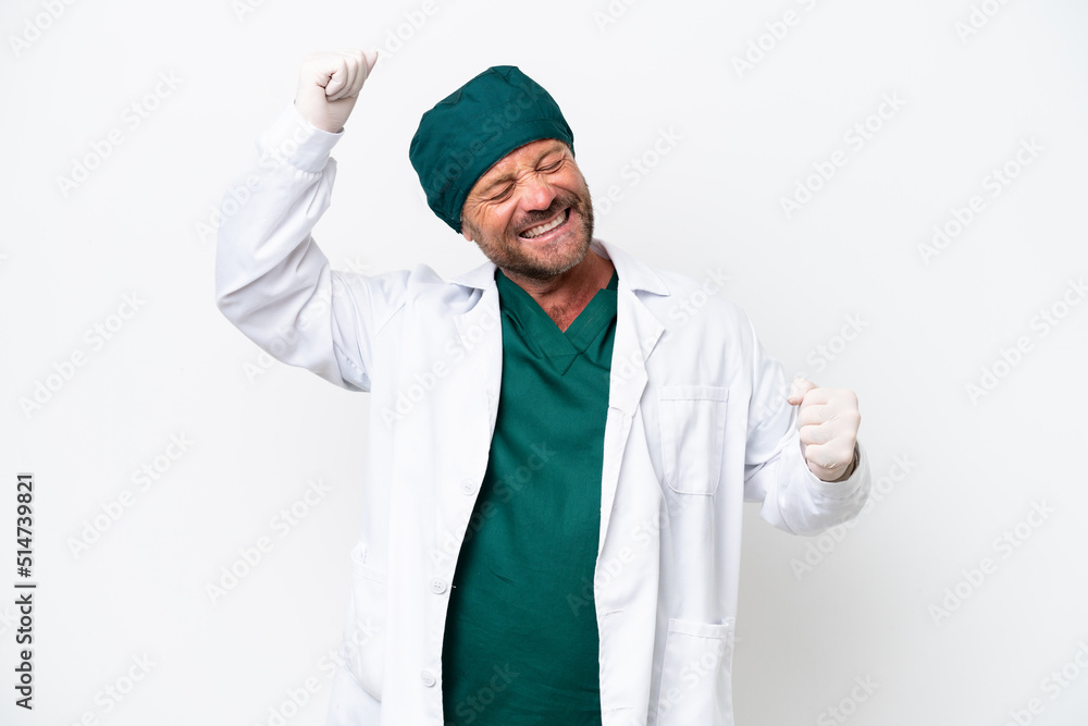 Middle age surgeon in green uniform isolated on white background celebrating a victory Middle age surgeon in green uniform isolated on white background celebrating a victory