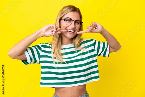 Blonde Uruguayan girl isolated on yellow background giving a thumbs up gesture