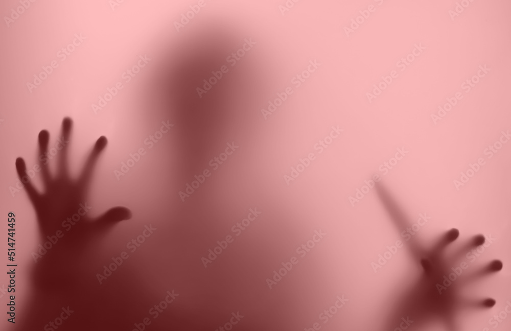 silhouette in a red haze blurred, stands with a knife, a maniac in the window - in a nightmare