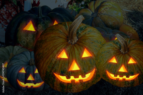 big pumpkin and little jack lantern with glowing eyes in the dark toned design