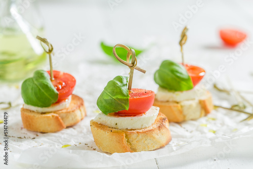 Canvas-taulu Hot and crisp crostini with tomatoes, basil and mozzarella