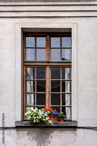 Old wooden window frame with flowers in the town © Eli Bolyarska