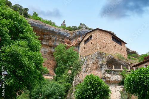 Stone house over a big rock close of a cliff at Orbaneja del Castillo