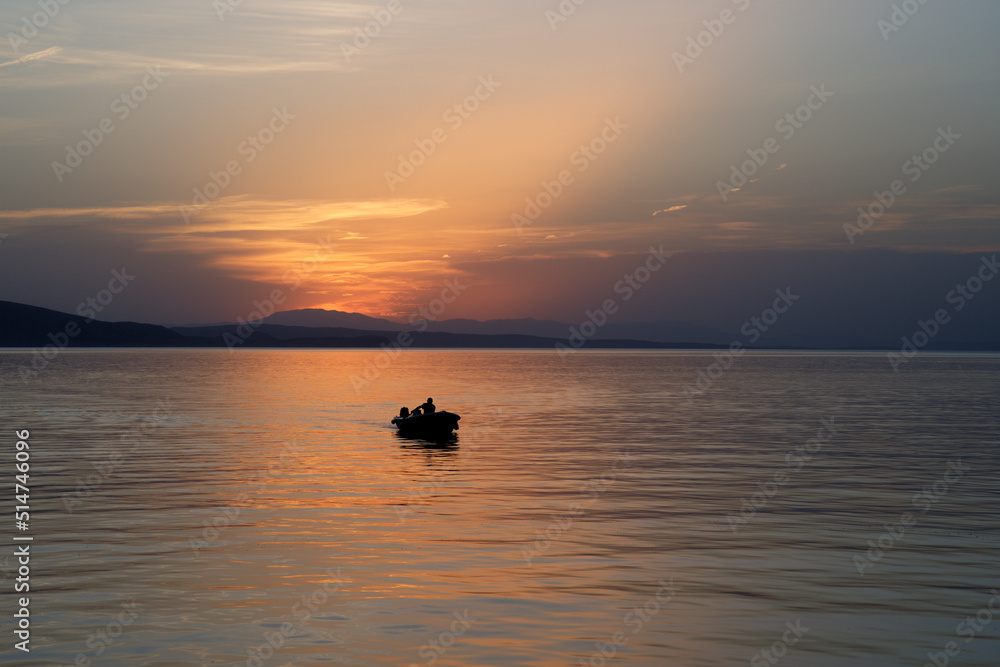 Barque de pêcheur dans un coucher de soleil sur la mer adriatique