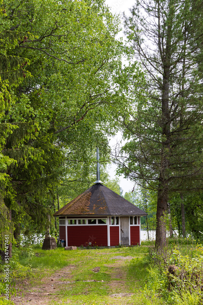 Typical Finnish little wooden shed with fire place along lake at the countryshide