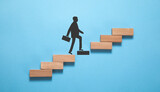 Businessman climbing on career ladder made by wooden block. Personal development. Career growth