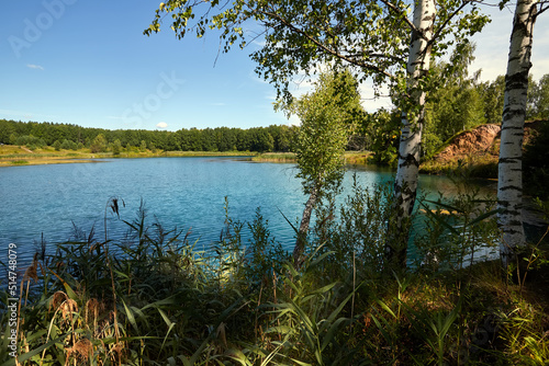 Carta da parati Beautiful lakeside view from a small lake in Russia, with lush green trees, blue