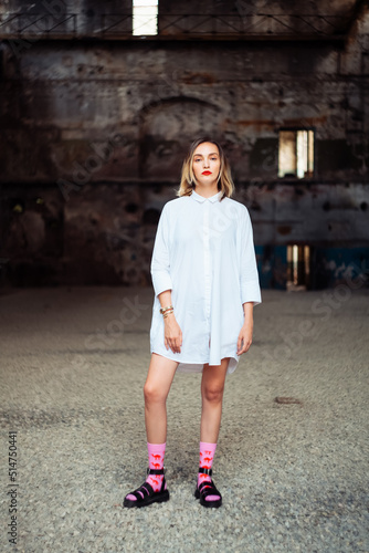 young fashionable woman in a white shirt in an old abandoned spacious building