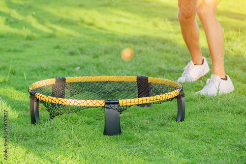 Obraz na płótnie Playing ball with mini beach volleyball net on a green grass lawn. Modern Leisure sports and fun recreation with friends w salonie