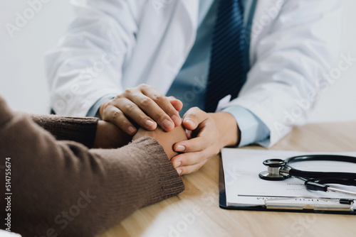 Close-up of psychiatrist hands together holding palm of his patient. Hands of patient reassuring his colleague. psychiatrist has encouragement the patient by touching to make his feel relaxed.