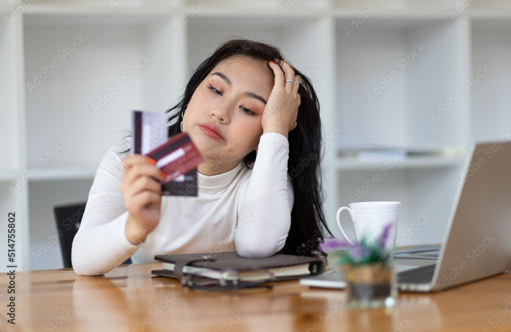 Asian woman worried about overspending and stressed to credit card debt. Concept of financial problems.