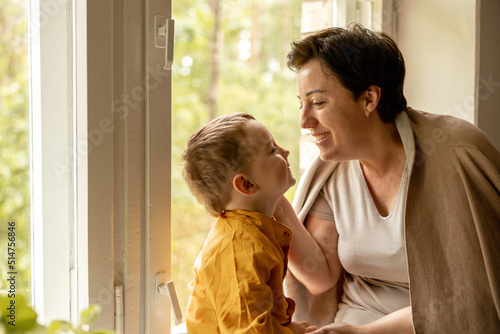 Happy grandmother and grandson enjoy time together. Positive middle age woman spending time with little, cute grandchild. 50-year-old grandma with grandkid. Multi-generational family.