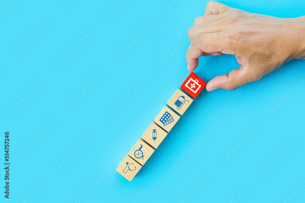 Hand choose medicine bag on cube wooden toy blocks stack with other health care and safety medical symbols concepts of healthy or sick prevent and illness treatment and insurance. Hand choose medicine bag on cube wooden toy blocks stack with other health care and safety medical symbols concepts of healthy or sick prevent and illness treatment and insurance.