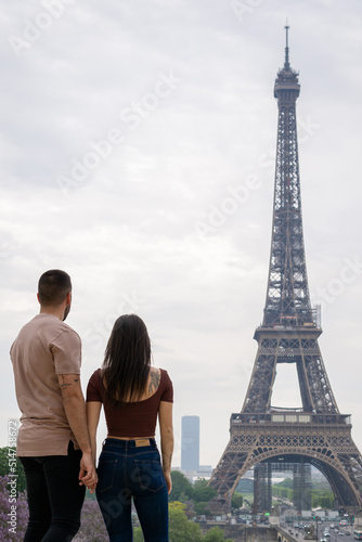 Young couple in love looking at the eiffel tower in paris from afar. © ANGEL LARA FOTO
