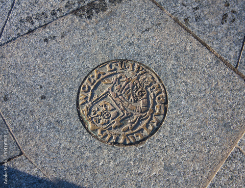 Emblem on the tile near Sculptural composition "City scales" in Old Town of Minsk, Belarus