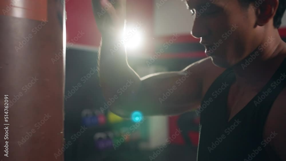 4K Strong Asian sportsman boxer with boxing gloves do sport training workout boxing exercise with punching bag at gym. Active athlete man practicing fighting exercise kickboxing at fitness club. 4K Strong Asian sportsman boxer with boxing gloves do sport training workout boxing exercise with punching bag at gym. Active athlete man practicing fighting exercise kickboxing at fitness club.