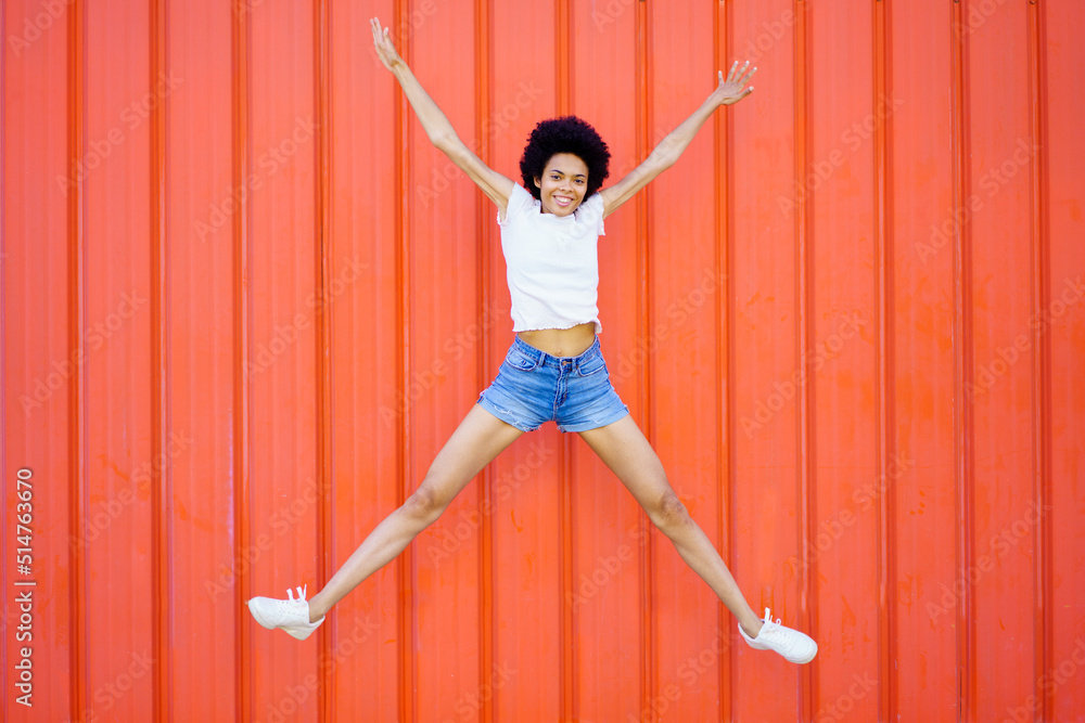 Happy black woman jumping on street Happy black woman jumping on street