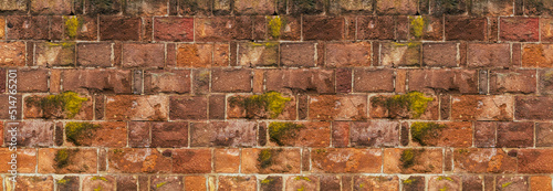 stone wall of red bricks covered with moss, part of the old pavement of the city © Kai Beercrafter