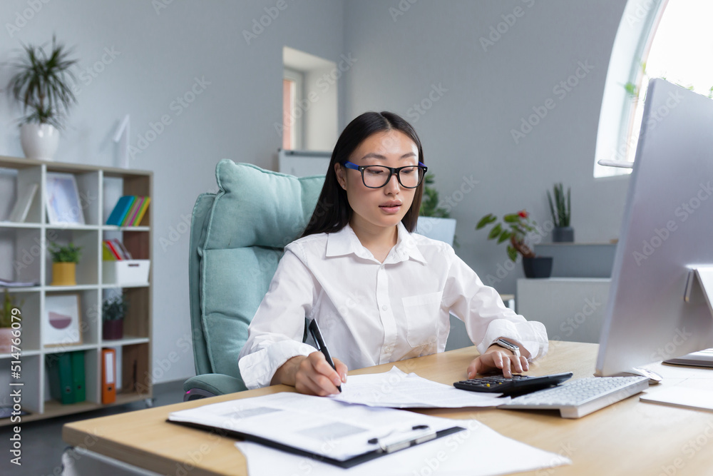 Serious thoughtful and confident woman working in office, asian worker businesswoman behind paper work. Serious thoughtful and confident woman working in office, asian worker businesswoman behind paper work.