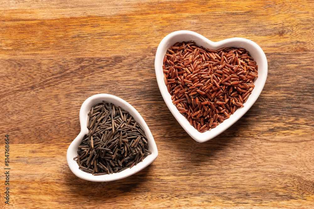 brown and black rice long in a white plate in the shape of a heart close up brown and black rice long in a white plate in the shape of a heart close up