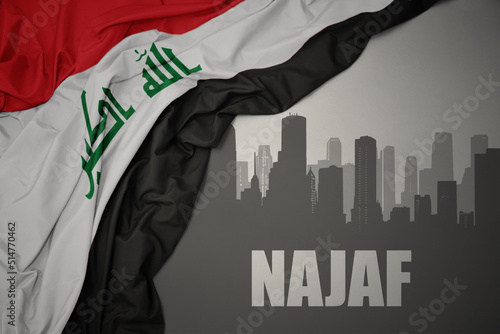 abstract silhouette of the city with text Najaf near waving national flag of iraq on a gray background.3D illustration photo