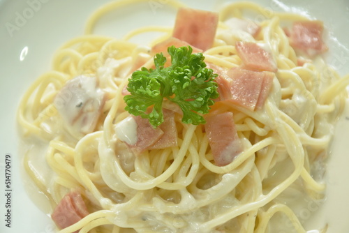 steamed spaghetti white cabonara cream sauce topping slice ham pork on plate photo