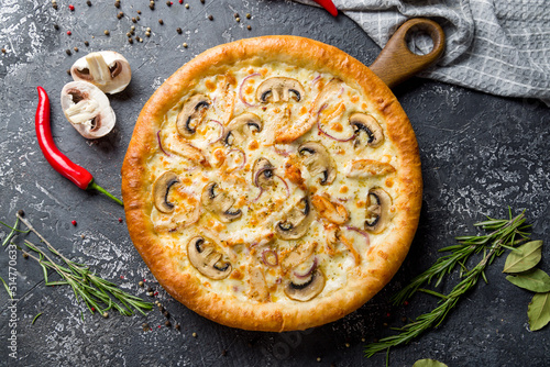 Pizza with chicken and mushrooms with cheese top view on dark stone table