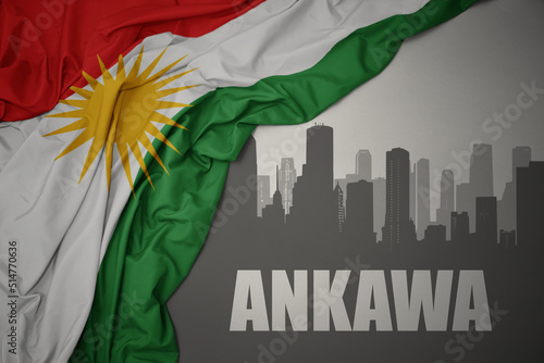abstract silhouette of the city with text Ankawa near waving national flag of kurdistan on a gray background.3D illustration photo