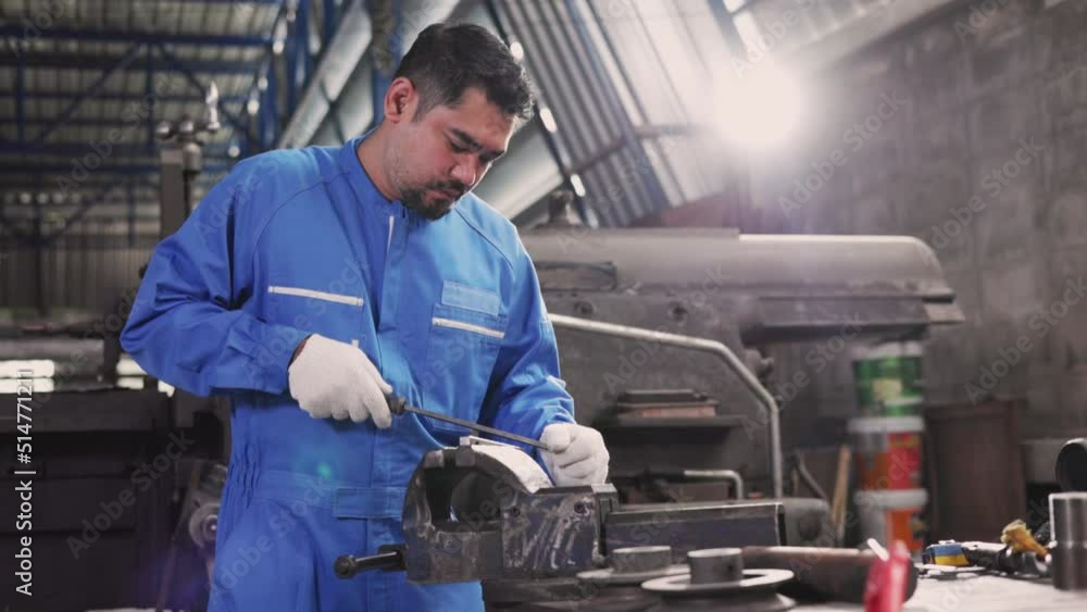 Engineer senior man wearing safety helmet working and checking machine automotive part warehouse factory.Happy female worker looking at the camera.Teamwork technicians are inspecting auto parts. Engineer senior man wearing safety helmet working and checking machine automotive part warehouse factory.Happy female worker looking at the camera.Teamwork technicians are inspecting auto parts.