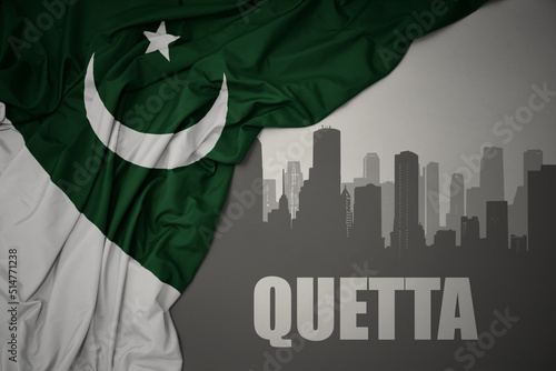 abstract silhouette of the city with text Quetta near waving national flag of pakistan on a gray background.3D illustration photo