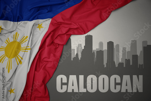 abstract silhouette of the city with text Caloocan near waving national flag of philippines on a gray background.3D illustration photo