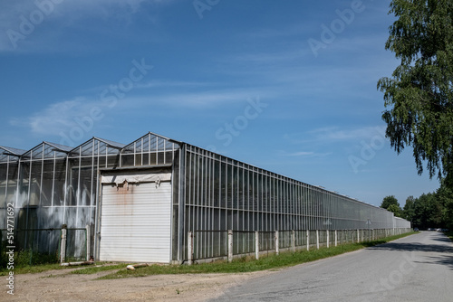 long industrial glass greenhouse along the road