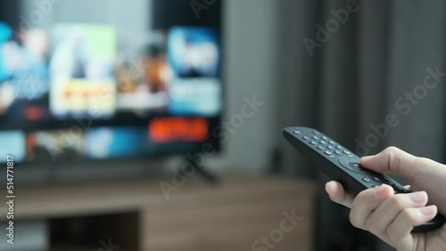 women hand holding the TV remote control and turn off smart tv. Channel surfing, focused on the hand and remote control. Internet TV at living room on holiday on sofa