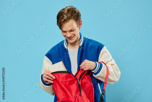 Foto a young student in a bomber jacket takes out a notebook from his backpack lookin
