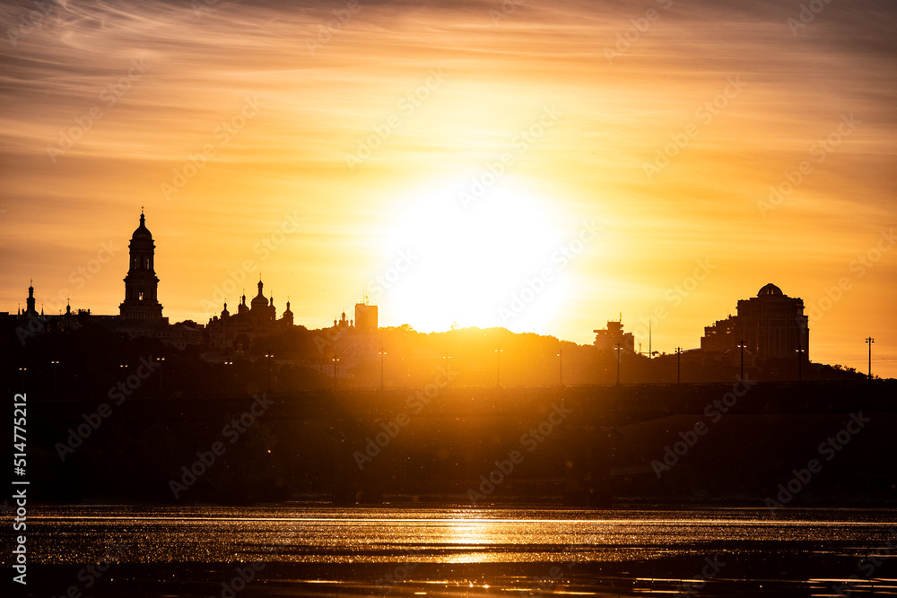Fototapeta premium Beautiful Ukrainian sky with bright sub and city silhouette on background. Yellow color heaven.
