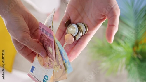 Hands hold different euro banknotes and euro coins. State aid in times of crisis to compensate for inflation. Salary increase and basic social security. Inflation, purchasing power and social crisis.