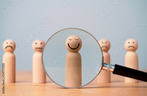 Foto Smiley face on wooden figure with inside magnifier glass for focus of satisfy and happiness of excellent customer evaluation concept