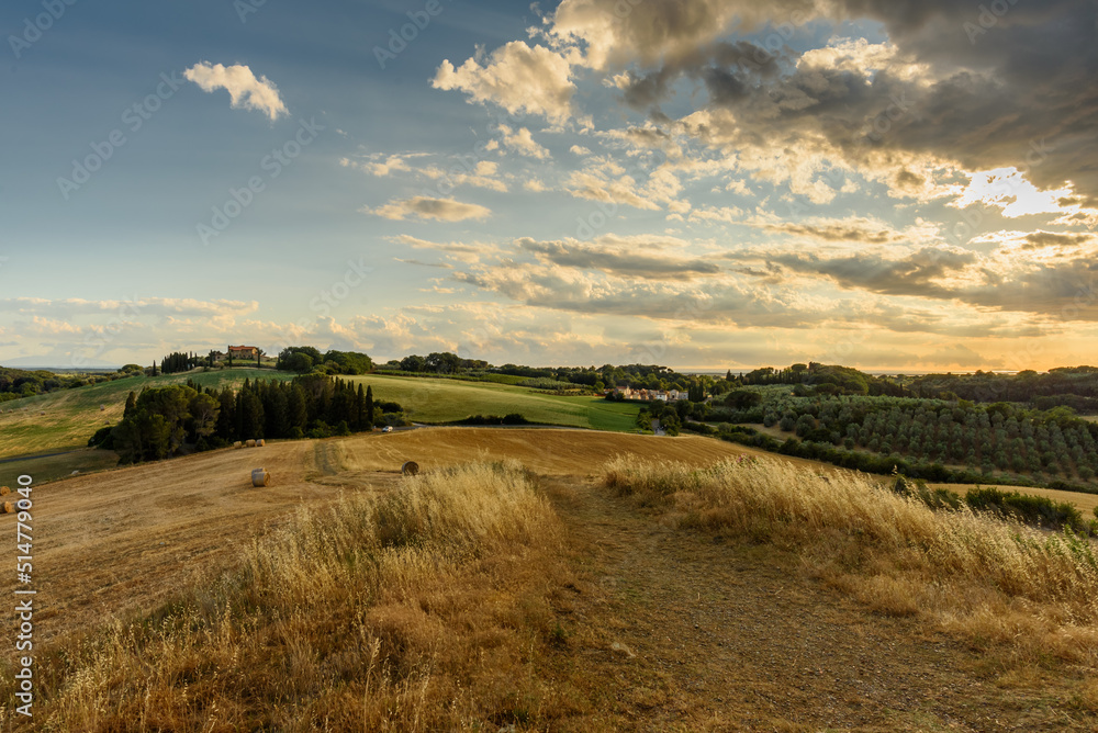 Landschaft in der Toskana mit Hügeln, Häusern und Straße bei Sonnenuntergang