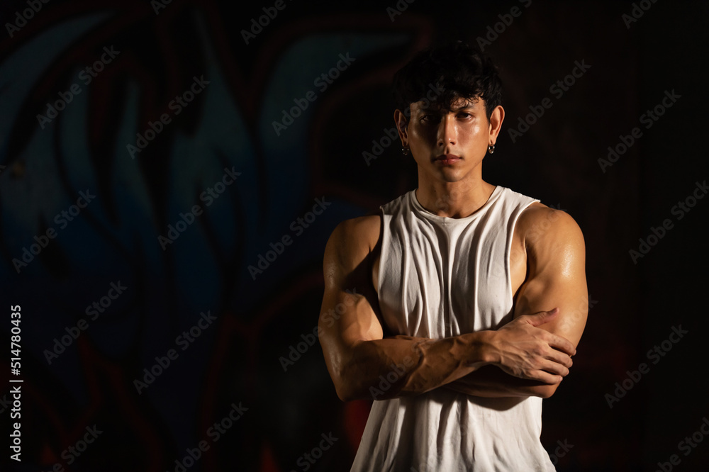 Portrait of Strong Asian sportsman athlete do sport training workout exercise bodybuilding in abandoned building. Active man bodybuilder practicing muscular strength training in dark old gym